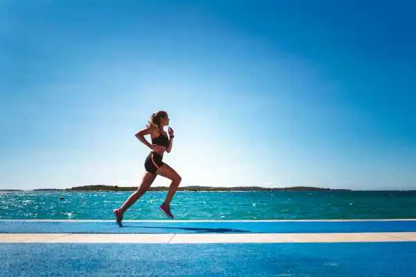 Woman running showing strong leg muscle Kington